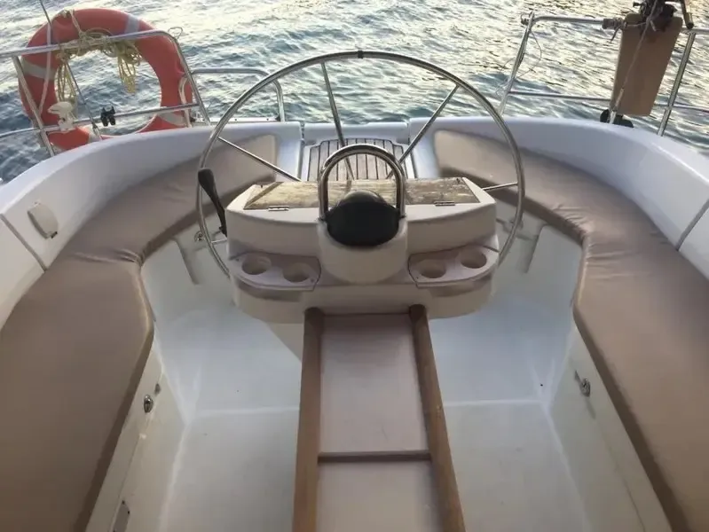 Cockpit of the sailing yacht with the steering wheel and cushioned seats